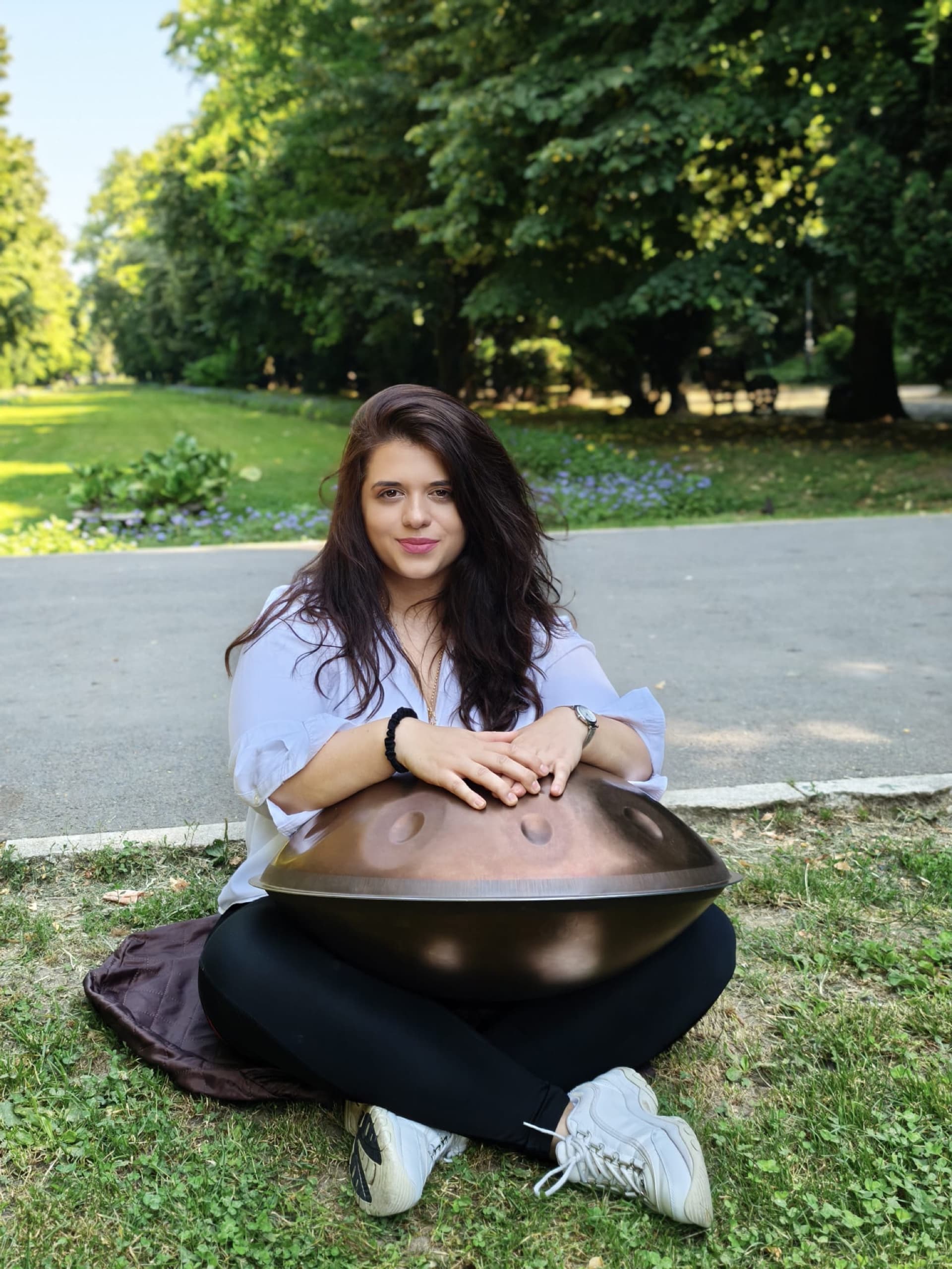 Ina Șerban, facilitator de sound healing din București, cu un handpan în parc